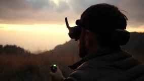 silhouette of a young man flying a fpv drone in nature using goggles headset vr headset in the mountain - Powered by Shutterstock - Get 15% off with code: PIKWIZARD15