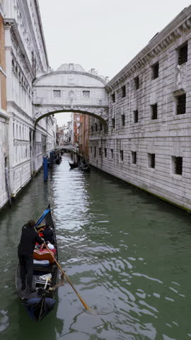 Gondola navigating venice canal, bridge of sighs view. Action