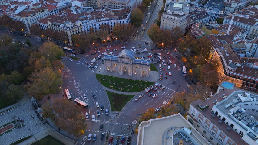 Experience the breathtaking aerial views of Puerta de Alcal in Madrid as the sun sets, showcasing the citys vibrant atmosphere and historic architecture