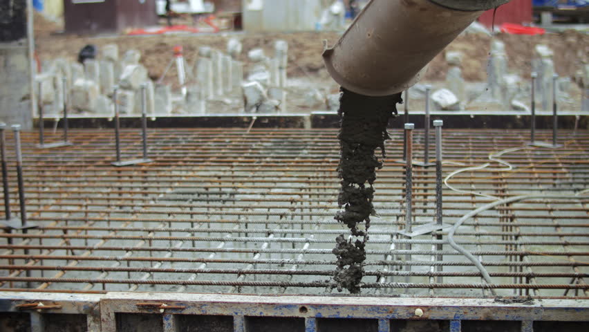 Concrete being poured onto steel reinforcement grid