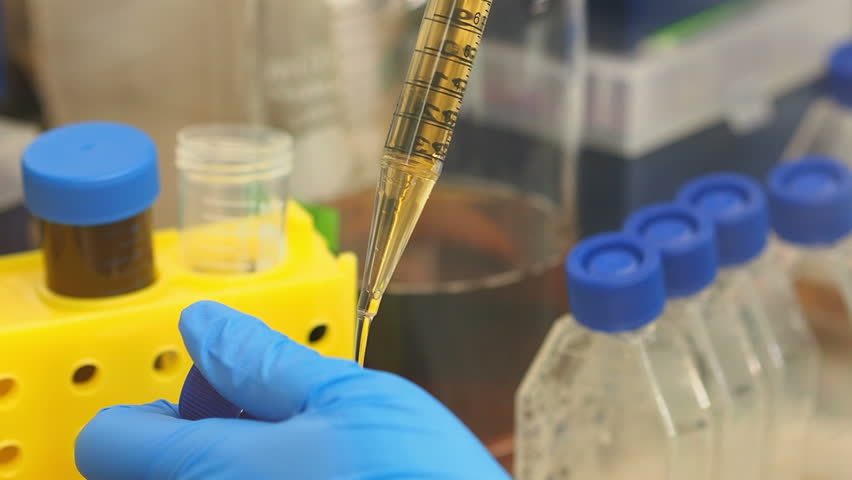 Scientist works in a lab- close up of chemical assay