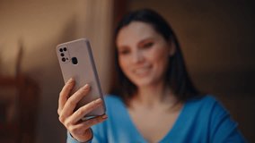 Brunette shopping online by smartphone at dark apartment closeup. Smiling woman satisfied internet purchases using cellphone app in night home. Happy lady reading mobile phone message in living room. - Powered by Shutterstock - Get 15% off with code: PIKWIZARD15