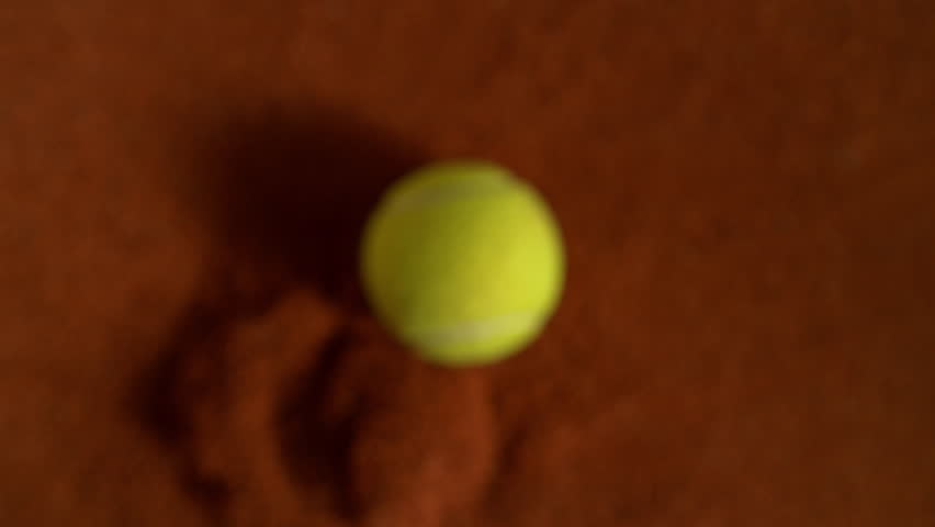 Super Slow Motion Flying Tennis Ball and Orange Clay Explosion Towards Camera at 1000fps.