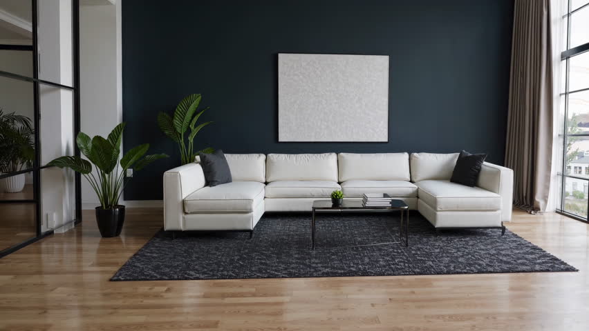 This stylish and modern living room showcases a beautiful white sectional sofa along with vibrant greenery throughout