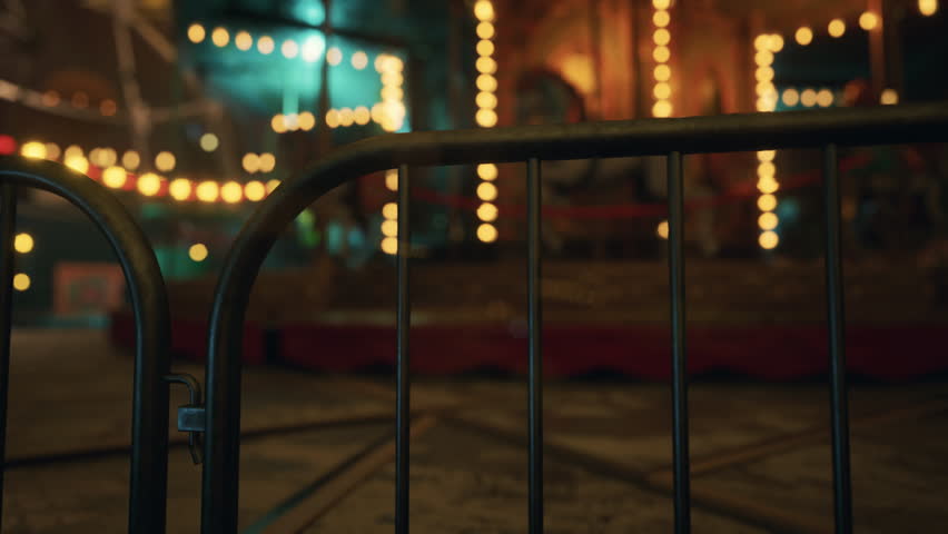 The amusement park is eerily quiet at night, with colorful lights glowing and rides standing still, creating a haunting yet beautiful atmosphere. No visitors are in sight.