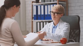 A healthcare professional discusses nutrition with a lady patient in a modern clinic. The dietitian is reviewing dietary plans and providing guidance on healthy eating choices. - Powered by Shutterstock - Get 15% off with code: PIKWIZARD15