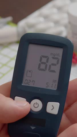 Vertical Screen: A man monitors his blood sugar levels with a glucometer and records the findings in his diary to manage his diabetes effectively.