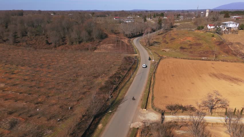 White Vehicle On Journey Over Countryside Road Of Georgia. Aerial Tracking Shot