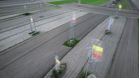 Orbit drone footage of power pylons crossing cultivated fields with energy color overlays indicating usage levels - Powered by Shutterstock - Get 15% off with code: PIKWIZARD15