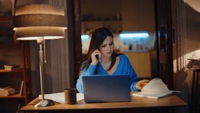 Worried employee calling mobile phone discussing documents mistake at dark apartment. Concerned lady freelancer talking cellphone sitting night home with laptop. Troubled woman speaking smartphone. - Powered by Shutterstock - Get 15% off with code: PIKWIZARD15