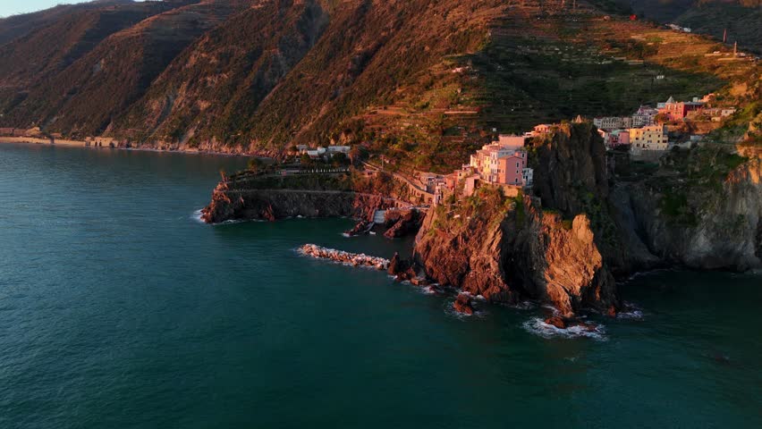 Riomaggiore village in the cinque terre at sunset, golden lighting, aerial view