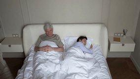 Domestic violence in family. Abusive mature husband tries to reconcile, touches wife shoulder in bed, but offended woman turns away in shock. Violence, cruelty, psychological discomfort, betrayal - Powered by Shutterstock - Get 15% off with code: PIKWIZARD15