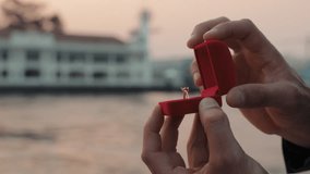 Man hand opens box offering engagement ring to fiancee on yacht deck against sea harbor closeup. Partner proposals presenting luxury jewelry for romantic feelings sailing ship - Powered by Shutterstock - Get 15% off with code: PIKWIZARD15
