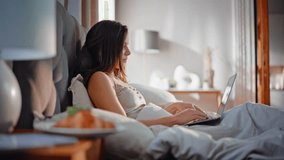 Businesswoman working computer in bed enjoying morning coffee closeup. Beautiful woman typing laptop drinking hot beverage on home beddings. Relaxed remote worker browsing gadget lying on soft pillows - Powered by Shutterstock - Get 15% off with code: PIKWIZARD15