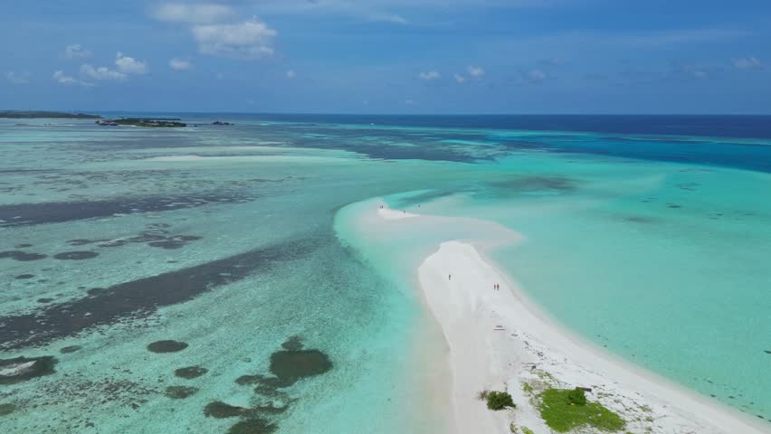 Aerial view of sandbank near Thulusdhoo island.Maldives.Group of people walking on white sandy sandbank at hot sun day.Slow motion video