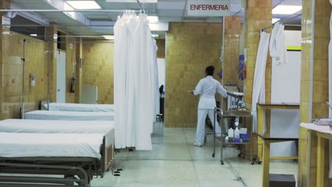 Nurse cleans the beds in the er room of an hospital in Latin America.