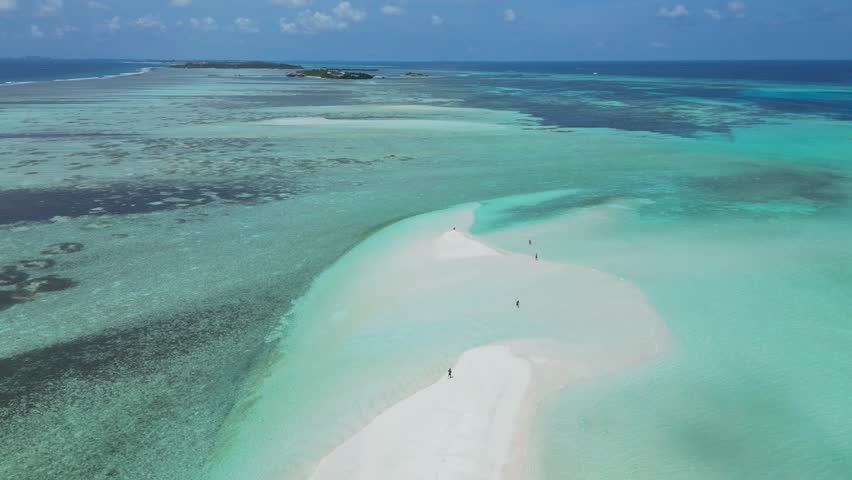 Aerial view of sandbank near Thulusdhoo island.Maldives.Group of people walking on white sandy sandbank at hot sun day.Slow motion video