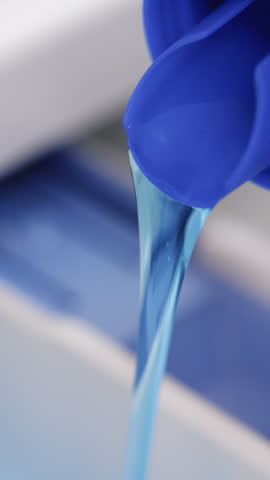 Vertical Format Video of Woman pouring detergent gel and put into washer machine, close the door and start washer. Household chores concept