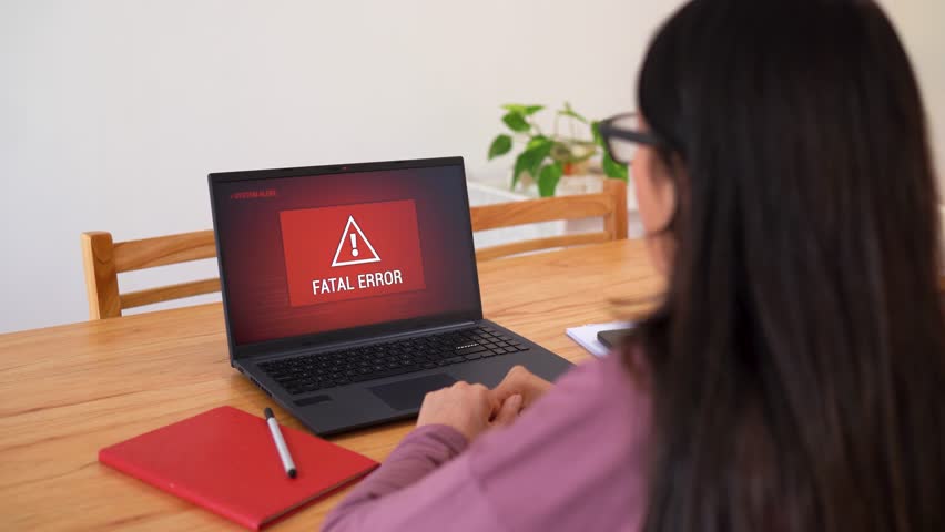 Portrait Of An Upset Woman In Front Of A Red Screen Fatal Error Laptop. Selective Focus Shot
