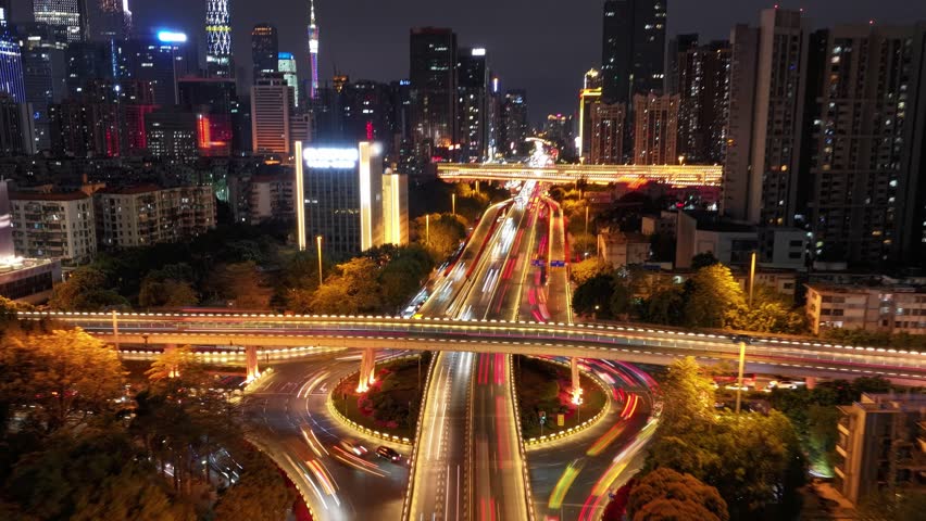 Night China cityscape time lapse. Lot cars drive transport interchange. Road traffic timelapse. Chinese aerial view fast urban highway. Modern city metropolis, skyscrapers buildings. Busy express way.
