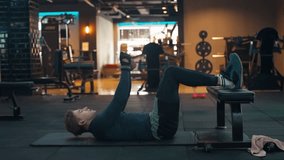 Man Doing Twisted Crunches with Kettlebell Exercise for the Abs and Obliques in Modern Gym - static slow motion - Powered by Shutterstock - Get 15% off with code: PIKWIZARD15
