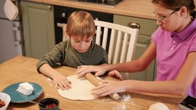 Teen Girl cooking pizza with brother. Little 6 years boy cooking pizza with sister in the kitchen. Children rolling up the dough, adding cheese, smear sauce. Kids making homemade pizza. Child baker - Powered by Shutterstock - Get 15% off with code: PIKWIZARD15