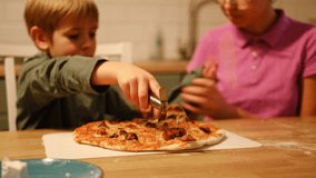 Teen Girl cooking pizza with brother. Little 6 years boy cooking pizza with sister in the kitchen. Children rolling up the dough, adding cheese, smear sauce. Kids making homemade pizza. Child baker - Powered by Shutterstock - Get 15% off with code: PIKWIZARD15