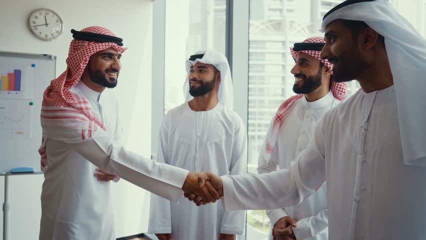 Cinematic video of a group of businessmen from Saudi arabia and Dubai during an corporate meeting in an office. Mixed business team from different parts of the UAE working together.