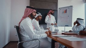 Cinematic video of a group of businessmen from Saudi arabia and Dubai during an corporate meeting in an office. Mixed business team from different parts of the UAE working together. - Powered by Shutterstock - Get 15% off with code: PIKWIZARD15