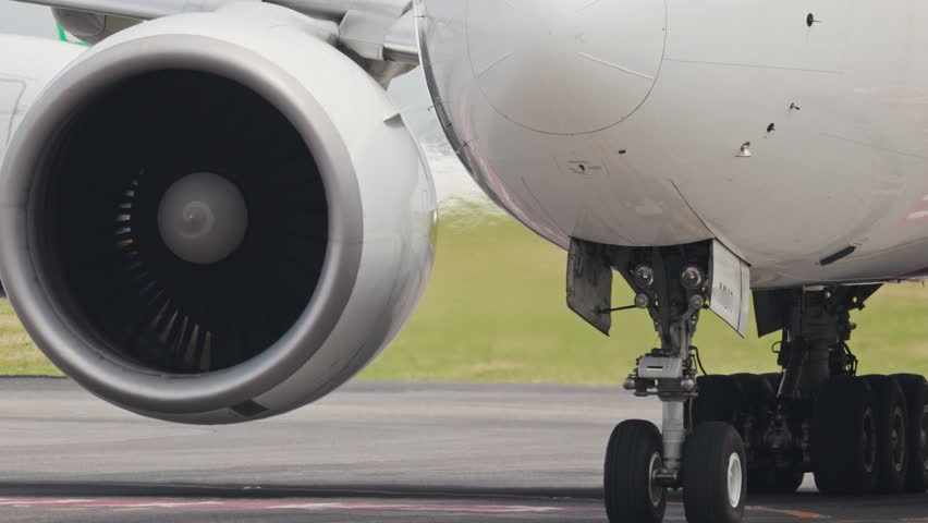 Large passenger airplane engine and landing gear on runway