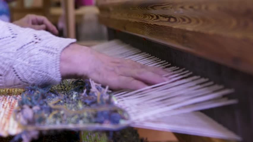 An Old Woman With Large Looms Weaves a Colorful, Decorative Tapestry or Carpet. Weaving is a Method of Textile Production in Which Two Sets of Yarns are Interlaced to Form a Fabric or Cloth.