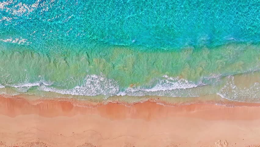 Big ocean waves background on tropical sandy coast. Calm Caribbean beach. Relaxing aerial beach scene. Soft turquoise blue ocean wave on yellow sand tropical beach.