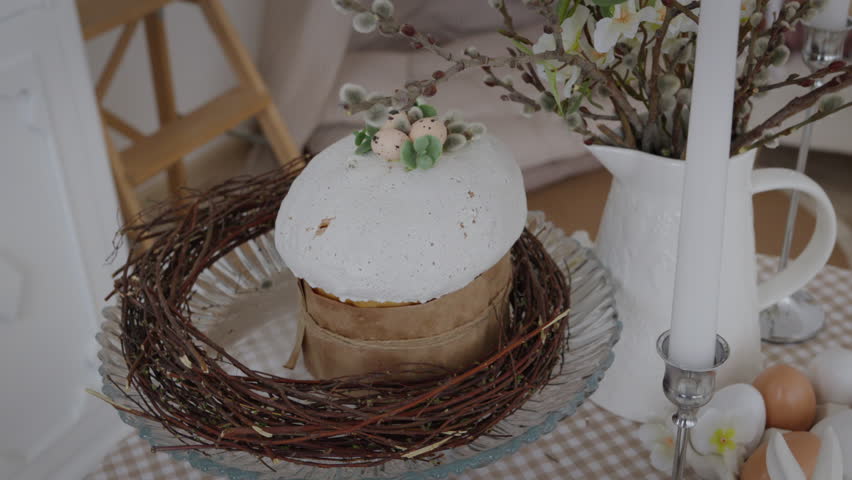 Close-up, beautiful table setting for the bright religious holiday Easter. Eggs, rabbits, Easter cake, panettone. Orthodox and Catholic Easter. Slow motion video 4k
