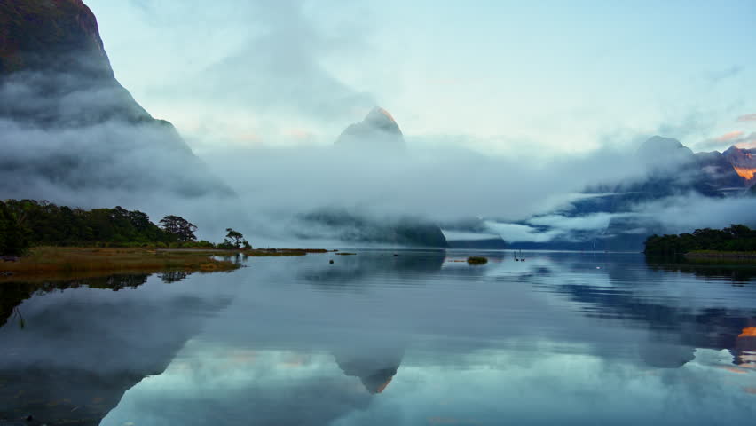Mysterious landscape of Milford Sound or Rahotu with Mitre peak in foggy on the lake during the morning at Fiordland national park, New Zealand