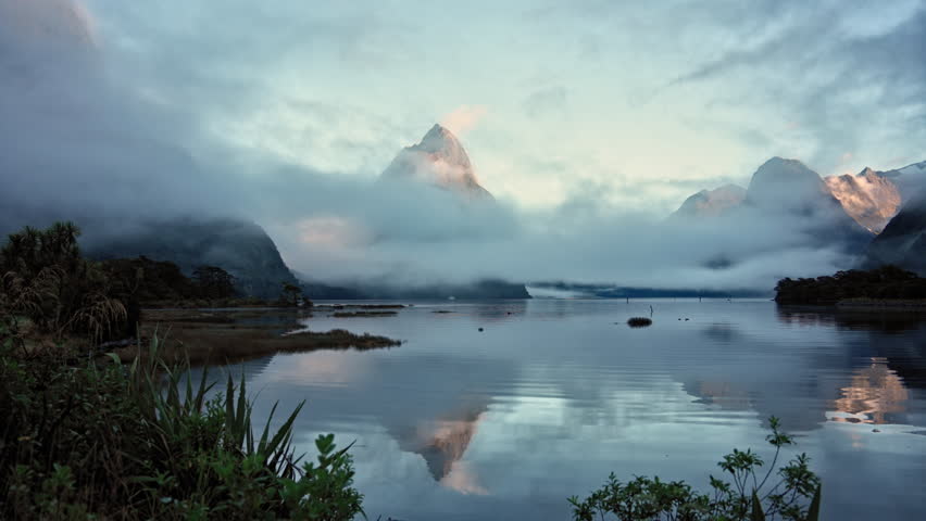 Mysterious landscape of Milford Sound or Rahotu with Mitre peak in foggy on the lake during the morning at Fiordland national park, New Zealand