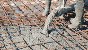 Close-up of wet concrete pouring from hose onto rebar grid with workers in rubber boots, High-detail macro of cement mix covering reinforcement for foundation construction - Powered by Shutterstock - Get 15% off with code: PIKWIZARD15