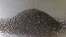 Dark synthetic diamond abrasive powder forming a dense pile on metallic surface, Macro close-up showing raw material used in heavy-duty cutting and grinding applications - Powered by Shutterstock - Get 15% off with code: PIKWIZARD15