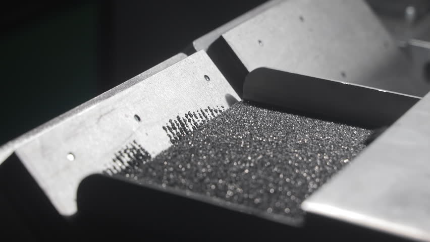Close-up of metal tray with abrasive diamond particles during disc manufacturing, Industrial process showcasing precise material control in diamond tool production