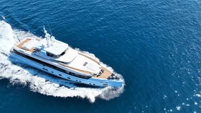 Aerial drone top down cinematic video of beautiful modern super yacht with wooden deck cruising in high speed in Aegean deep blue sea - Powered by Shutterstock - Get 15% off with code: PIKWIZARD15