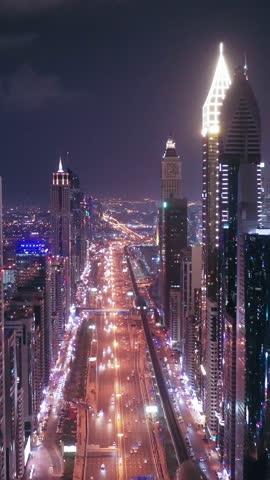 Night view of iconic skyscrapers and busy traffic on a major interchange in Downtown Dubai, UAE. Stunning skyline of a modern city, symbolizing business, finance, and urban development