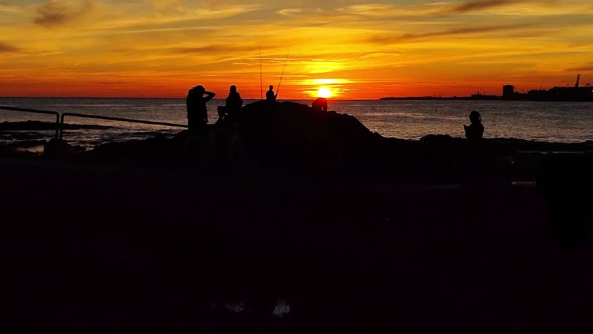 Wide shot video, sunset landscape scene at coast of rio de la plata river, at paseo de los pescadores, parque rodo neighborhood, montevideo city, uruguay