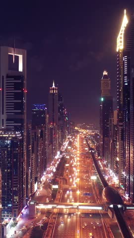 Night view of iconic skyscrapers and busy traffic on a major interchange in Downtown Dubai, UAE. Stunning skyline of a modern city, symbolizing business, finance, and urban development