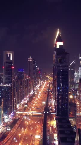Night view of iconic skyscrapers and busy traffic on a major interchange in Downtown Dubai, UAE. Stunning skyline of a modern city, symbolizing business, finance, and urban development