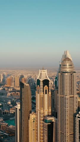 Aerial view of iconic skyscrapers and heavy traffic in Downtown Dubai, UAE. Modern skyline with luxury architecture, urban lifestyle, business district, finance hub, and smart city concept