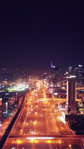 Night view of iconic skyscrapers and busy traffic on a major interchange in Downtown Dubai, UAE. Stunning skyline of a modern city, symbolizing business, finance, and urban development