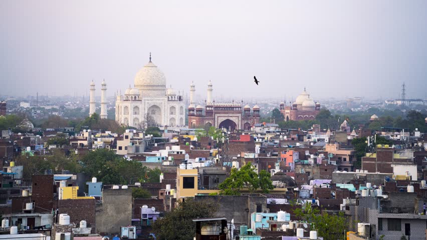 Aerial timelapse shot of Taj Mahal from evening to night with houses, buildings and other monuments visible as lights switch on showing time passing