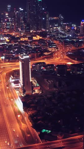 Night view of iconic skyscrapers and busy traffic on a major interchange in Downtown Dubai, UAE. Stunning skyline of a modern city, symbolizing business, finance, and urban development