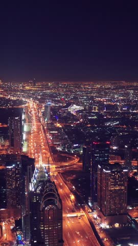 Night view of iconic skyscrapers and busy traffic on a major interchange in Downtown Dubai, UAE. Stunning skyline of a modern city, symbolizing business, finance, and urban development