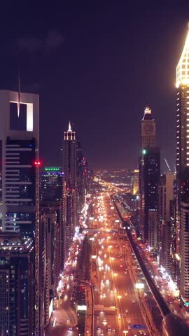 Night view of iconic skyscrapers and busy traffic on a major interchange in Downtown Dubai, UAE. Stunning skyline of a modern city, symbolizing business, finance, and urban development