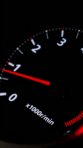 Close up of car speed meter. Footage. Interior of a modern car, dashboard with an engine speed dial and moving red arrow.